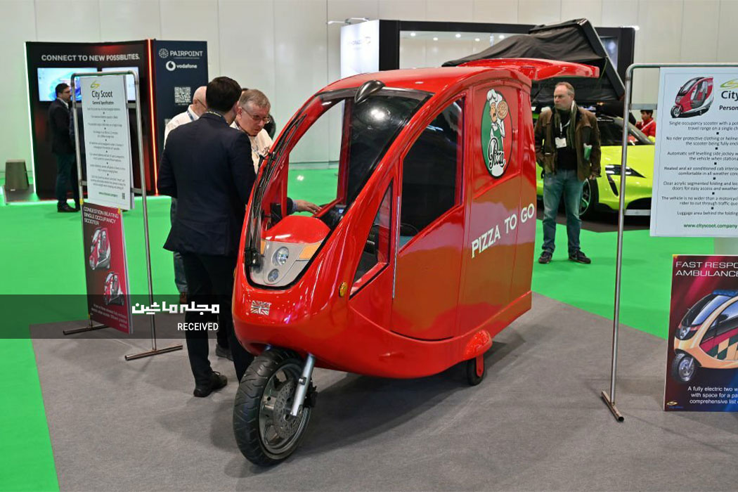 بازدیدکنندگان از یک اسکوتر برقی مخصوص حمل مواد غذایی در نمایشگاه خودروهای الکتریکی لندن 2023